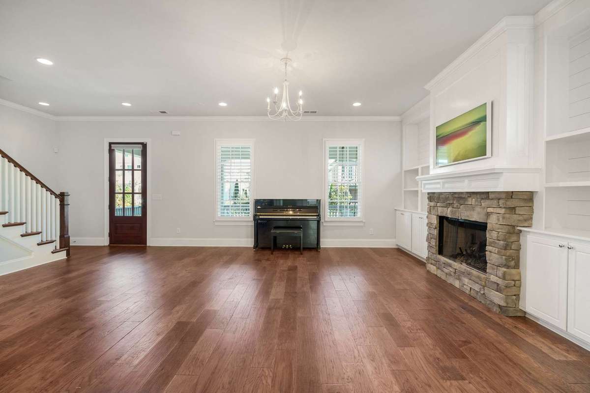Alternate view of the living space, large wooden front door, generous windows, and plantation shutters.   Main floor has 10 foot ceilings and 8 foot doors creating a wonderful scale