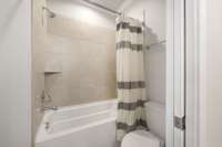 view of shared bath between bedroom #2 and #3.  large tub / shower combo and pocket door for privacy from vanity area