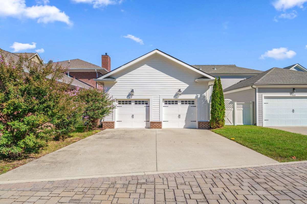garage is accessed off back cobblestone alley, and has extra space in driveway for vehicle parking. side yard fence has a gate entry