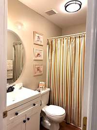 Hallway bathroom has a shower/tub combination.