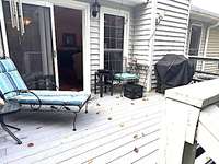 Recently painted back deck overlooks the fenced in backyard that backs up to a bluff.
