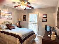 Bedroom # 2 has neutral colored carpeting, ceiling fan with light kit and wooden blinds.