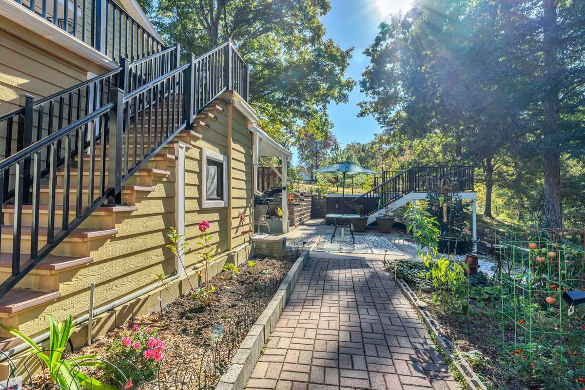 The brick walkway connects the open parking, outdoor shower and storage building to the rear living spaces