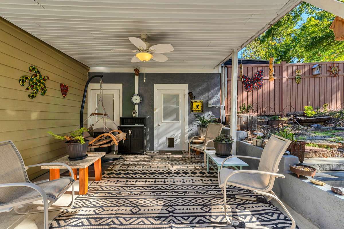 This covered patio is just off the garage. A peaceful water feature is to the right of the patio.