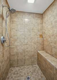 large tiled step-in shower in primary suite