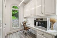 The built in Miele coffee maker and desk area elevate the experience of doing laundry!