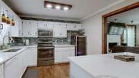 Kitchen with quartz counter tops, stainless steel appliances and wine cooler
