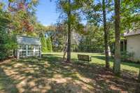 The greenhouse is nestled into a corner of the massive yard