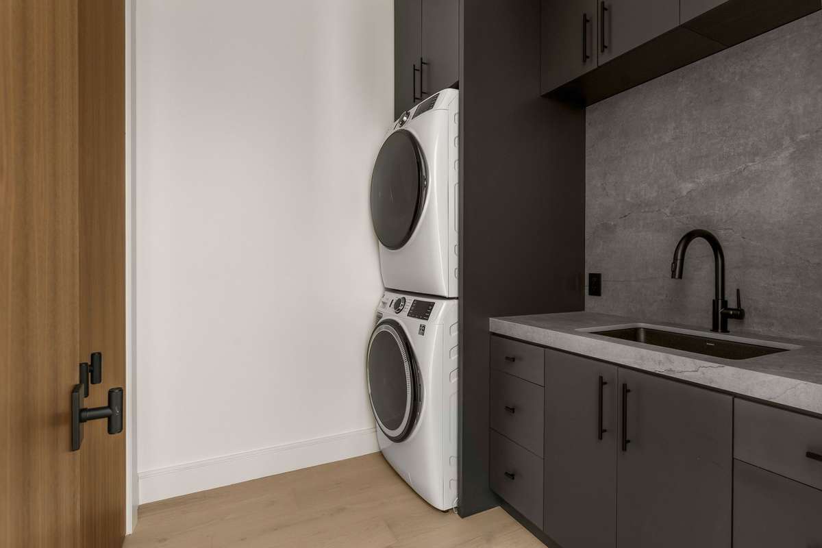 Elevated laundry room featuring custom cabinetry and refined details