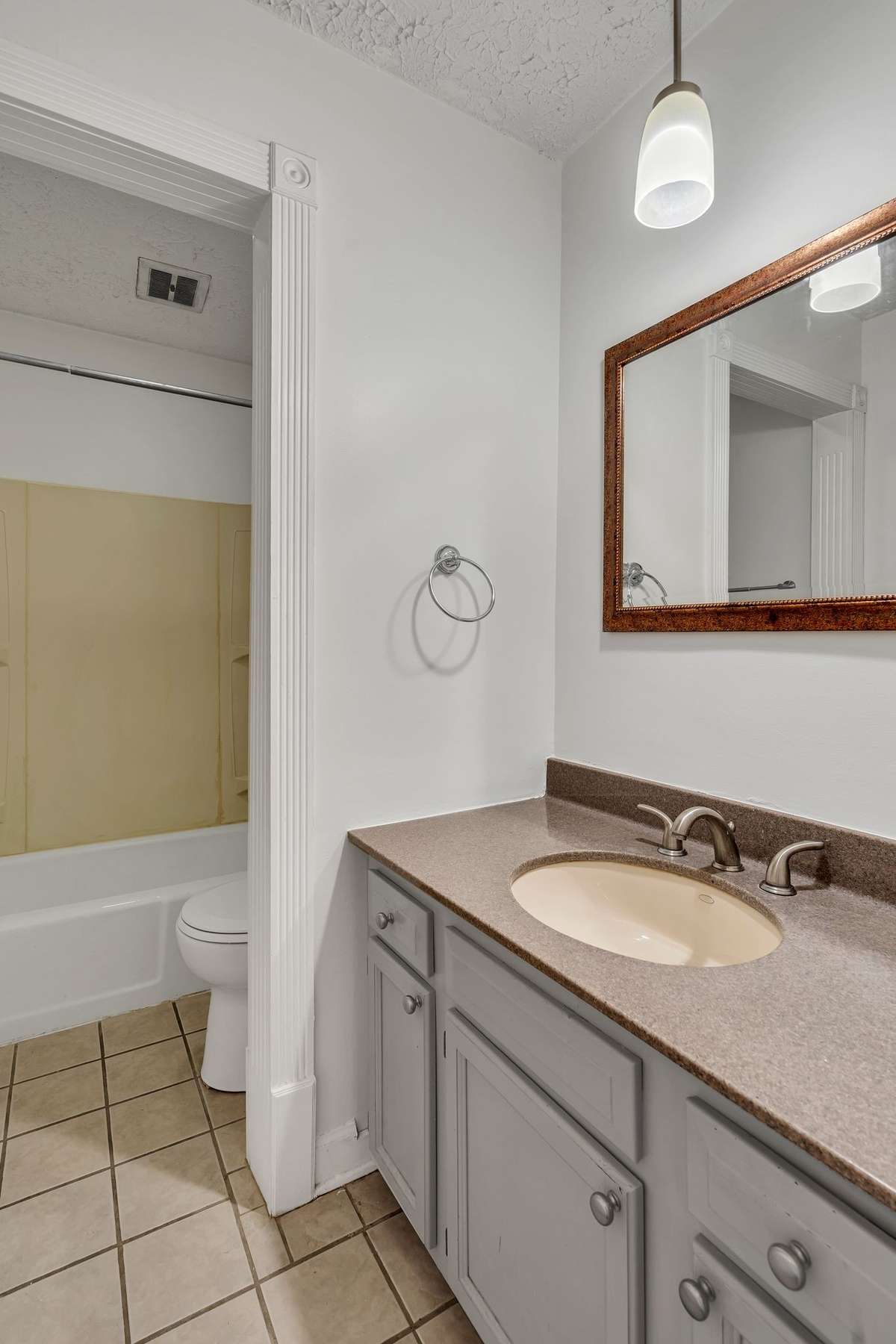The bathroom has a large vanity and tub/ shower
