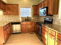 Custom Kitchen with Stainless Stove, Dishwasher and Microwave