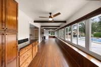 This sunroom overlooking the pool has multiple opportunities! A very transitional area to lounge with lots of natural light, a great area for kids or grandkids to use too!  Solar blackout shades on all windows.