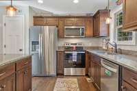 Kitchen with granite countertops and stainless appliances. The door opens to a large pantry.