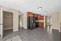 One view of the kitchen showing the pantry again, hallway to garage, laundry room and half bath. Refrigerator remains with home