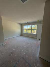 Spacious bedroom with soft natural light, neutral walls, and ample room for personalized furnishings and décor.