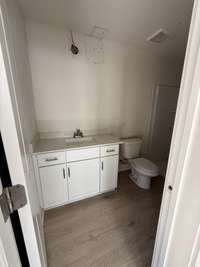 Timeless bathroom featuring a white vanity, sleek fixtures, and warm flooring.