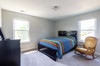 This is a spacious secondary bedroom with double windows.