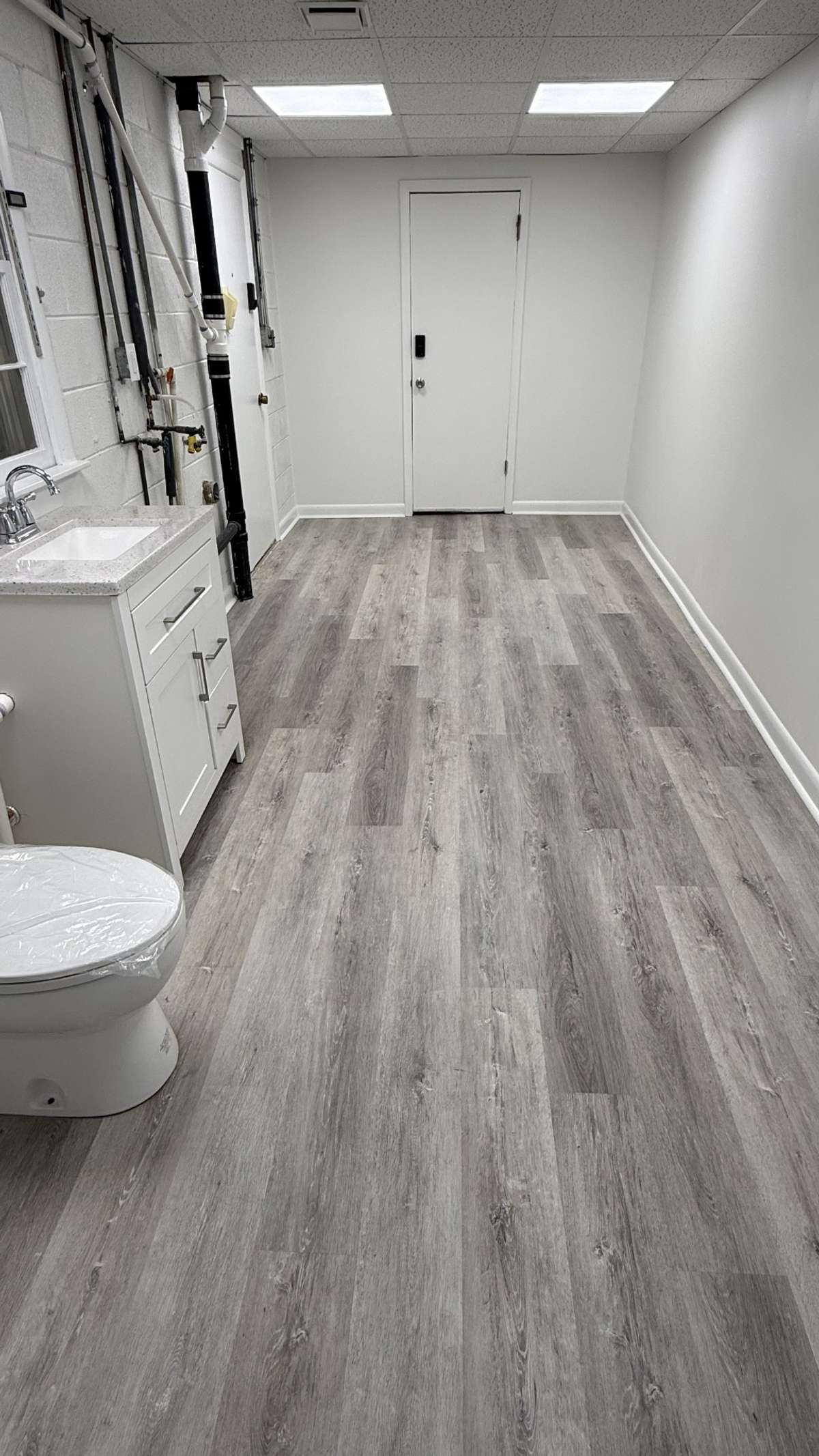 View of the downstairs Half Bath and also Washer and Dryer Hookups with shared Utility Room. With also entrance of the 2 Car Garage. This room is also ground level in the back side of the home