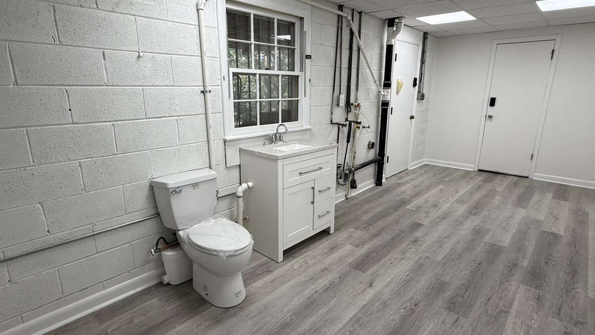 View of the downstairs Half Bath and also Washer and Dryer Hookups with shared Utility Room. Also entrance of the 2 Car Garage and view of the entrance of the covered Patio. This room is also ground level in the back side of the home