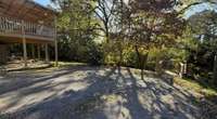 Parking area in Back of Home with Coevered Patio and Covered Deck with also a Small Deck.