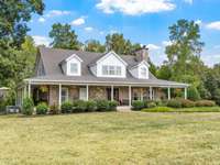 There is an 8 foot wrap around porch on this beautiful home. Look at the mature landscaping.