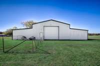 Back of building- Fenced dog area, single rollup door to main storage area