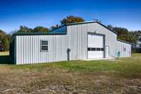 Front of building- Single 14x14 overhead door, concrete pad, and pedestrian door