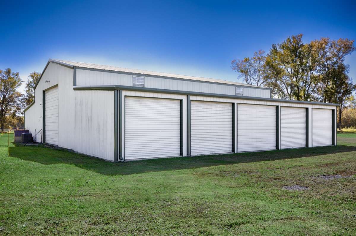 Side of building- Enclosed lean to with five overhead doors