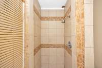 3/4 bathroom- tile flooring, tile shower, crown molding