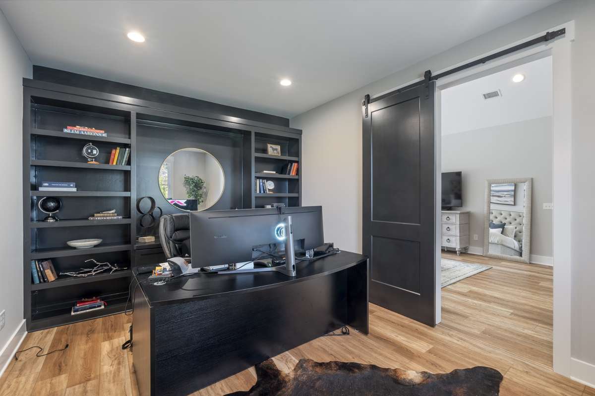 Currently being used as a dedicated home office with built-in shelving and a stylish barn door—perfect for working from home with privacy and organization.
