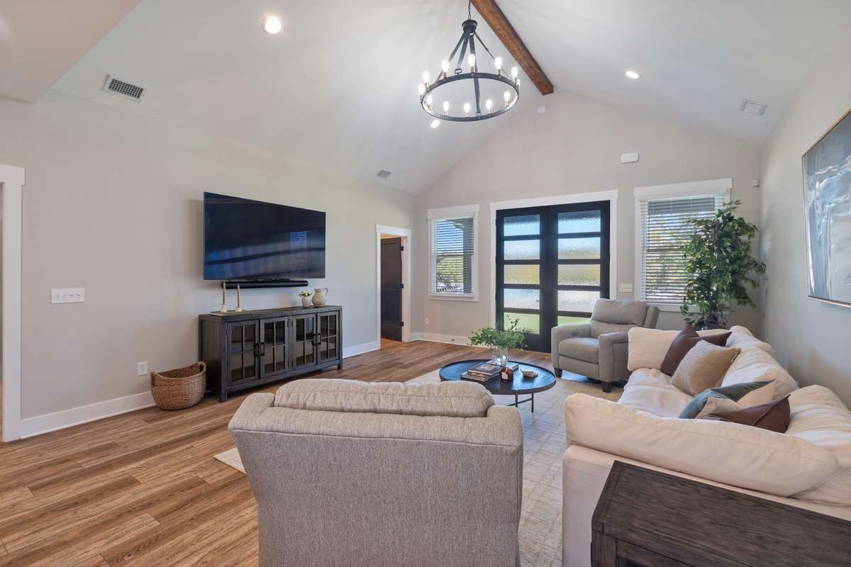 Recess lights and statement chandelier along with the wood beam highlight the vaulted ceilings.