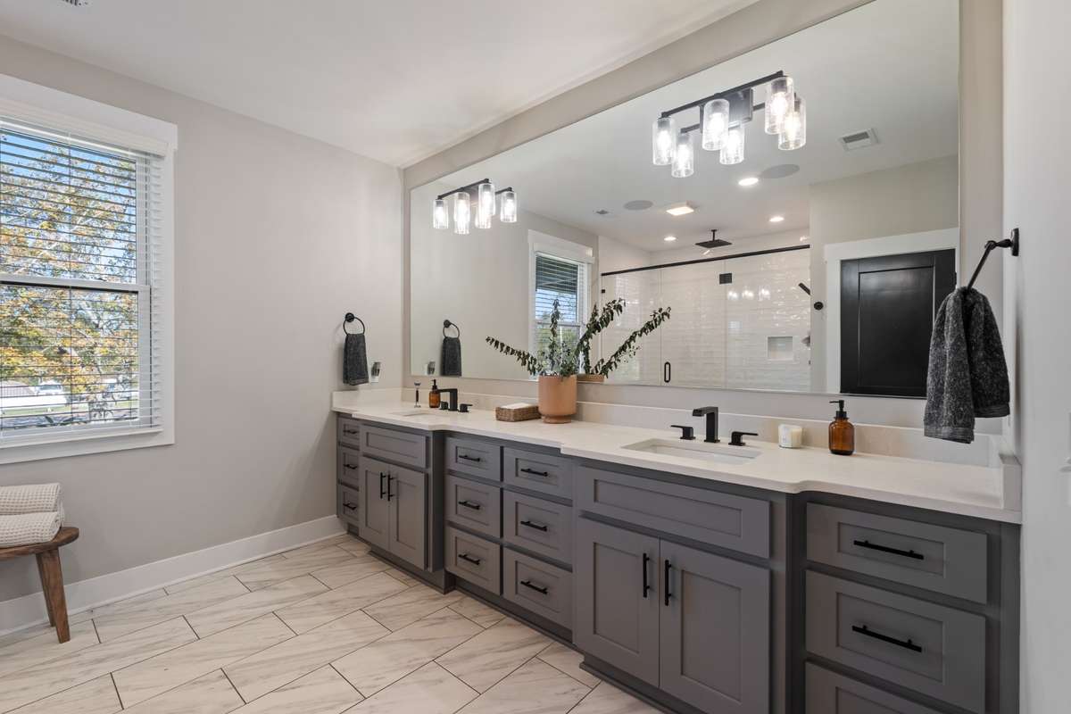 Primary suite bathroom has a 10 foot vanity with multiple stacks of drawers and quartz vanity top.