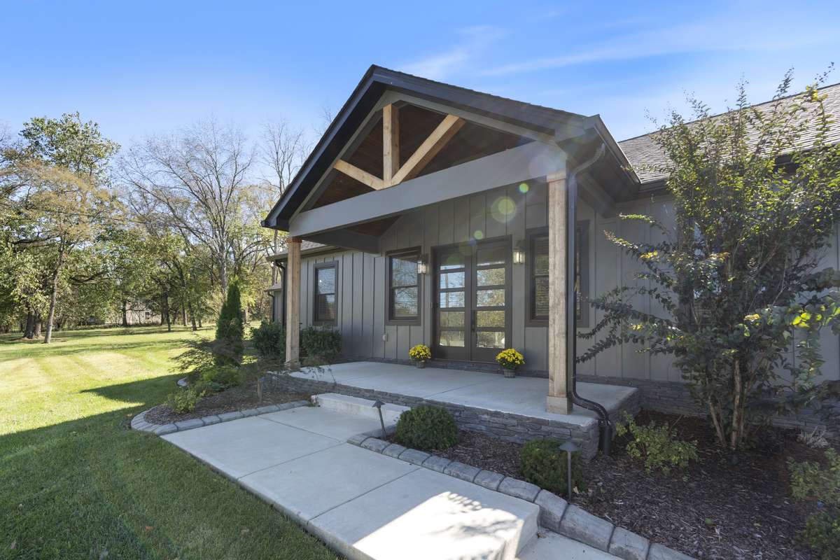 Double contemporary glass and wood doors flanked by additional windows set the tone for the open and airy design once inside.