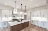 A beautiful kitchen with all of the luxury finishes from oversided island to pot filler to Butler's Pantry