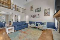 Soaring ceilings and a striking catwalk overlook this spacious living room, beautifully styled with charming lake-inspired décor—perfect for relaxing or entertaining in your Tims Ford Lake home.