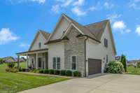 Charming craftsman-style home with standout curb appeal, featuring stone accents, a welcoming front porch, and beautiful landscaping.