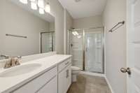 Primary Bath is Equipped with Double Vanities (not pictured), 5' Shower Insert with Glass Door, and Beautiful Ceramic Tile.