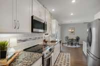 Kitchen has a large pantry and plenty of cabinets. Just beyond the kitchen is the garage and a conveniently located half bath.