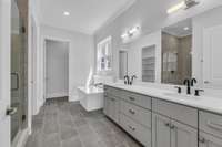 Enjoy double vanities, a walk-in shower, a soaking tub, and a large walk-in closet with upgraded built-in shelving!