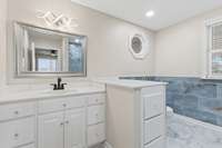 The primary bathroom on the first floor provides a relaxing retreat with a luxurious and serene atmosphere..