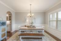 The dining room features wainscoting, lots of natural lights and curved door openings for extra character.