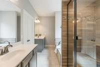 The primary bath has two separate vanites, a tile shower, soaking tub and tile floors.