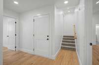 Just off of the living room you will find the Garage entry into foyer for primary bedroom, laundry room, half bath and 4th bedroom or bonus room upstairs.