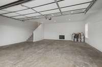 oversized 2 car side entry garage features recessed lighting.