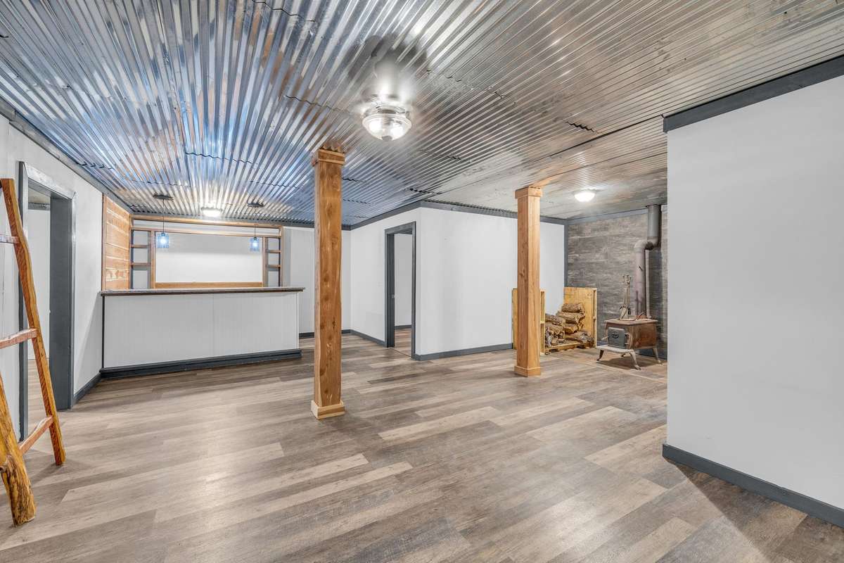Basement area with cedar columns, granite bar top, and wood burning stove.