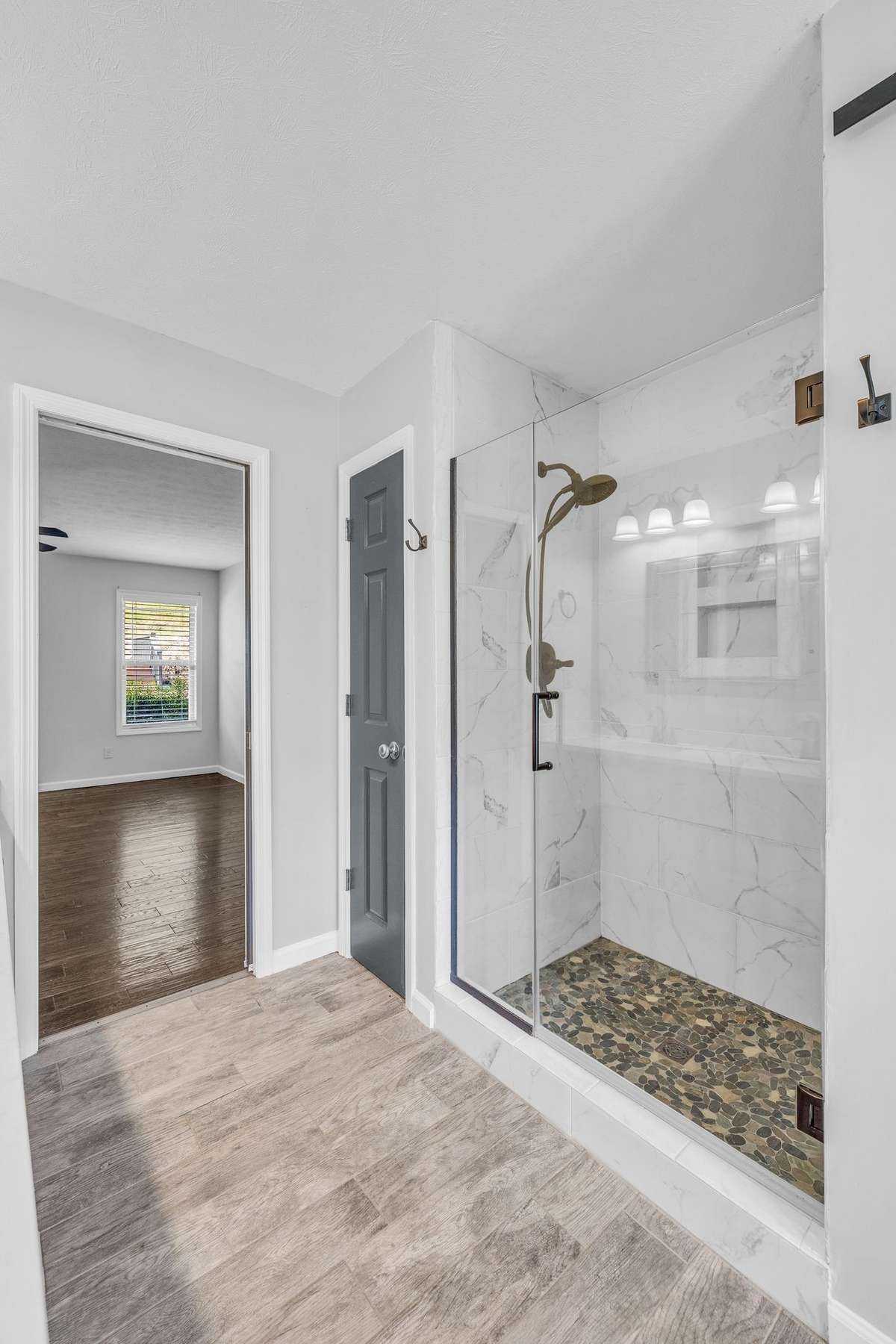 Primary bathroom has a tile shower, with tile floors.