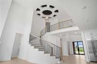 Make a stunning entrance every time with this elegant grand curved staircase, the architectural centerpiece of the home. As you step inside, your eyes are immediately drawn to the soaring volume ceiling that adds a sense of grandeur and airiness.