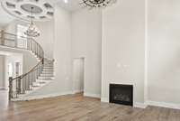 Step into a home that makes a lasting impression from the moment you arrive. The dramatic two-story entrance showcases a grand curved staircase, creating a stunning architectural focal point that exudes elegance and sophistication