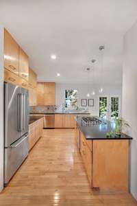 The refrigerator can remain with the home, making this move-in ready. Located off of the kitchen is a walk out pedestrian door that leads to the side yard.