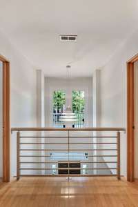 The upstairs hallway has a balcony view over the entry foyer of the home.